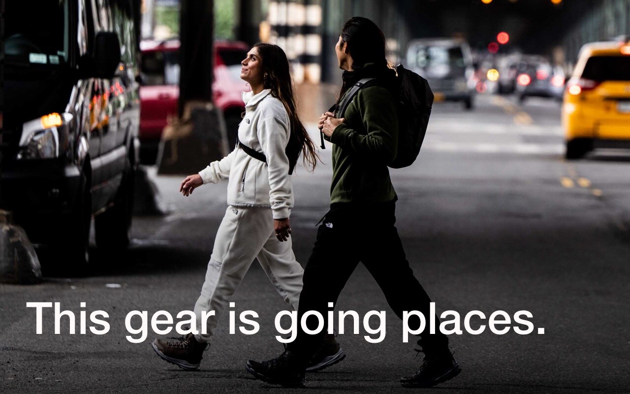 Two people wearing gear from The North Face are exploring busy city streets.