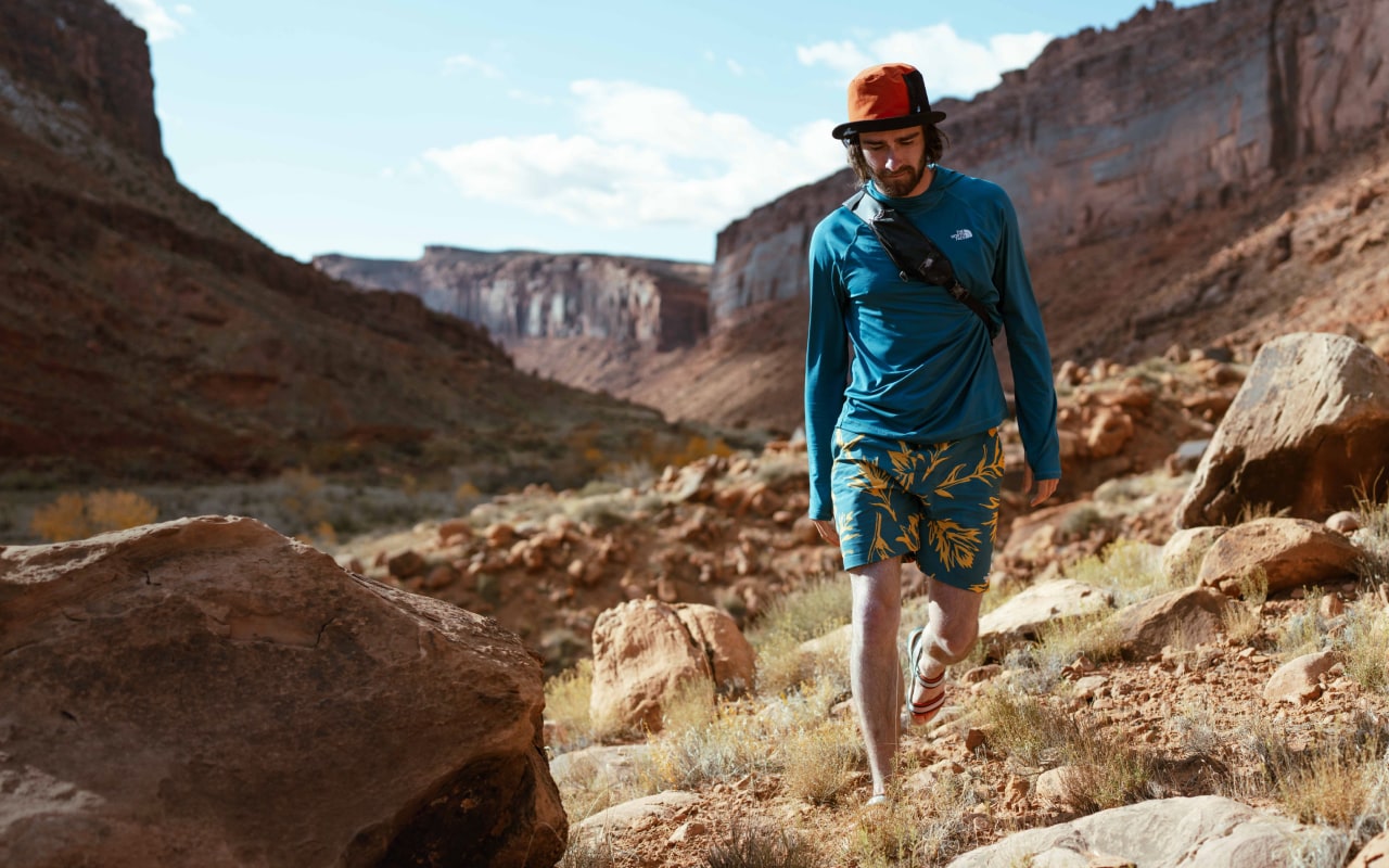 A hiker concentrates as he navigates a steep desert canyon.