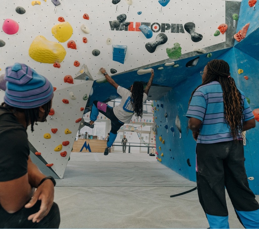 A climber makes their way up a bouldering wall at Memphis Rox climbing gym.