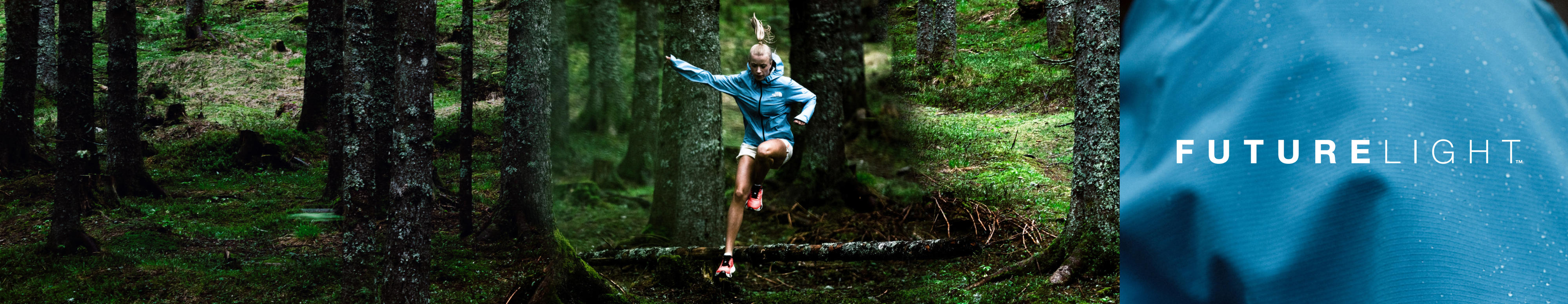 A trail runner hurdles over an obstacle in a lush forest.