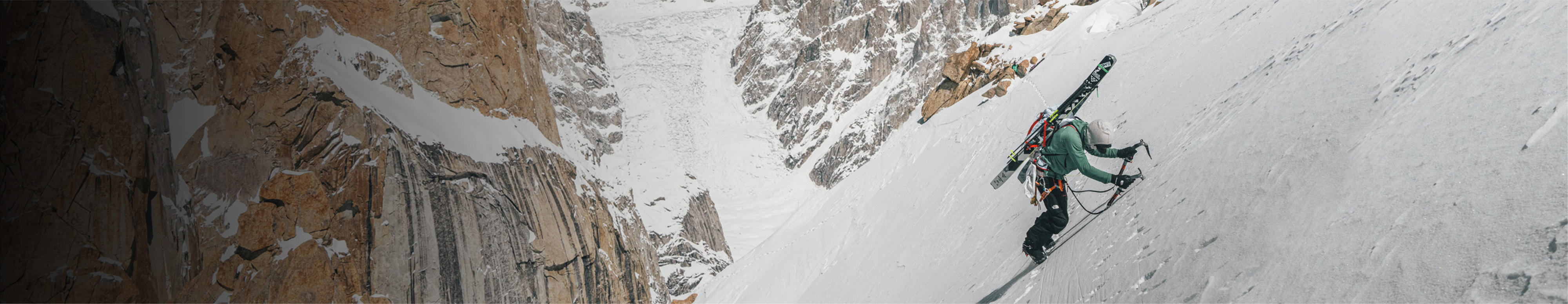 Un homme vêtu de l’équipement Summit Series de The North Face fait de l’escalade sur glace.