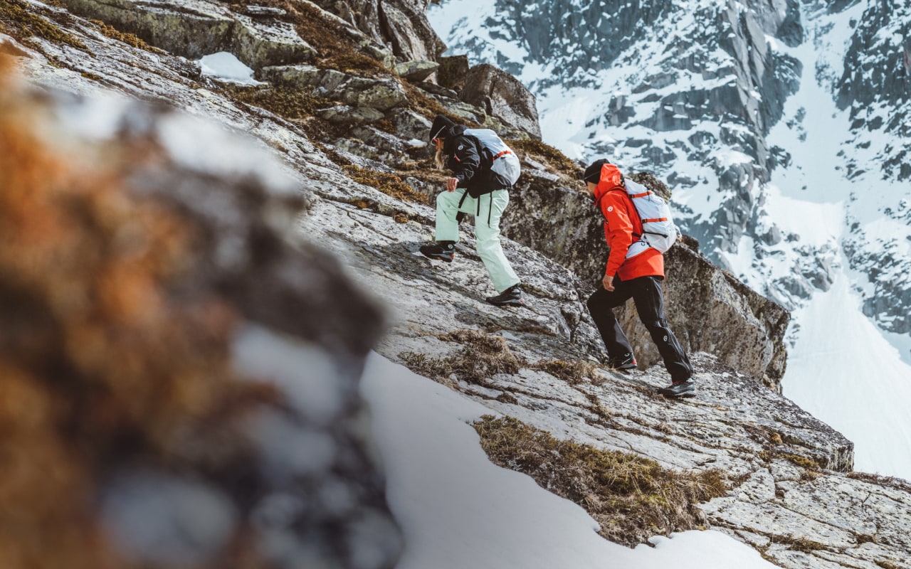 Deux personnes portant des vêtements de la série Summit de The North Face escaladent une montagne dans la neige.
