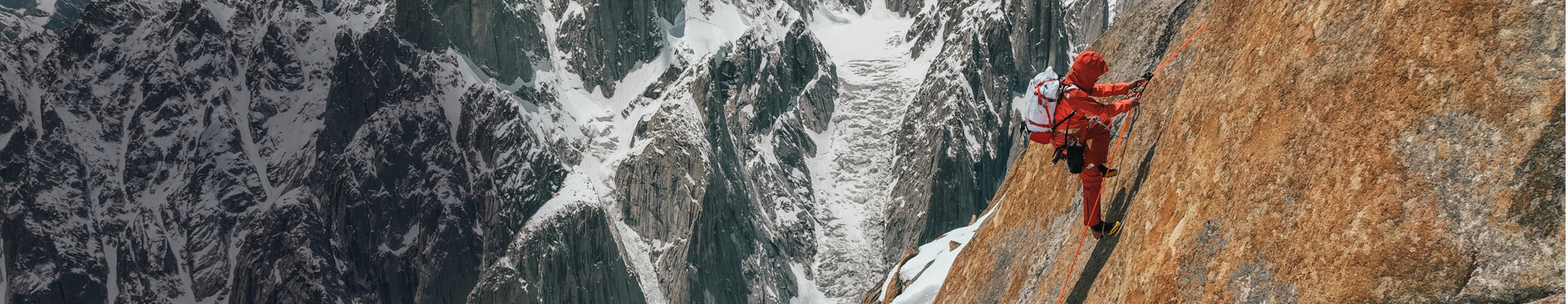 Une femme en tenue Summit Series de The North Face fait de l’escalade hivernale.