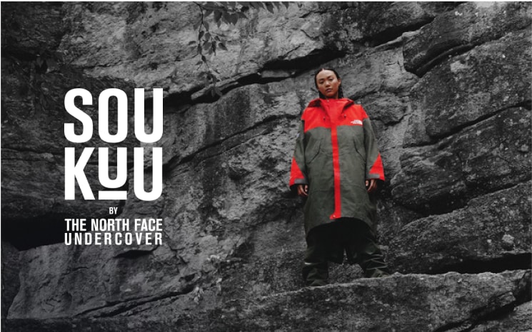 Person standing in front of a cliff wearing The North Face x Undercover SOUKUU collection.