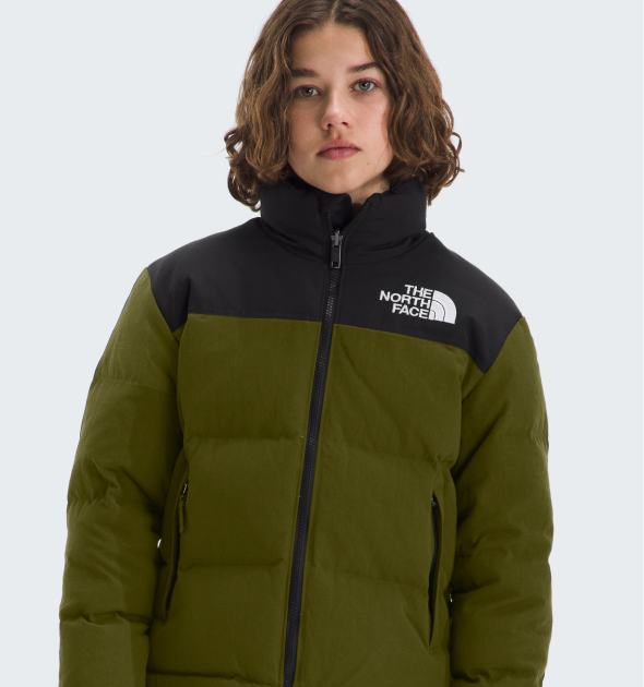 A child wearing the Big Kids’ 1996 Retro Nuptse Jacket. Text reads: “Ready for the warmup. Keep them on the move beyond winter with lightweight, breathable layers.”   HL: Ready for the warmup. 