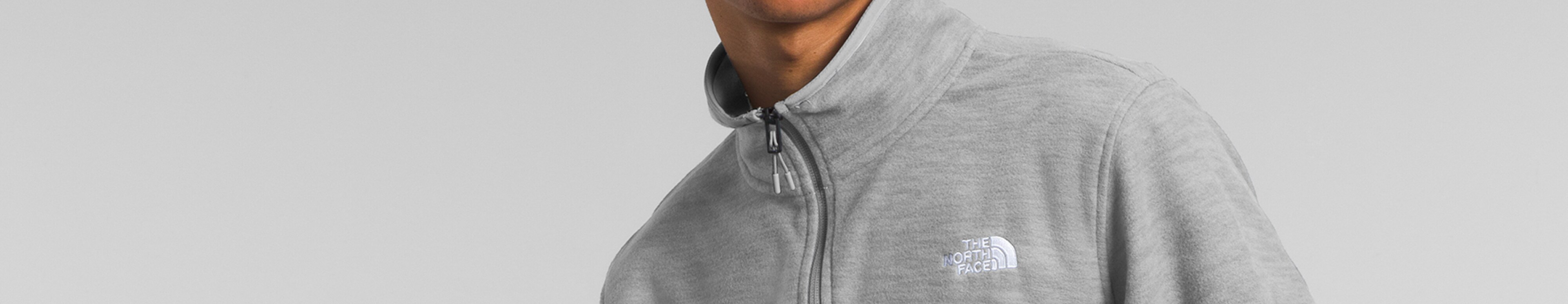 Studio shot of a man in a gray fleece from The North Face. 