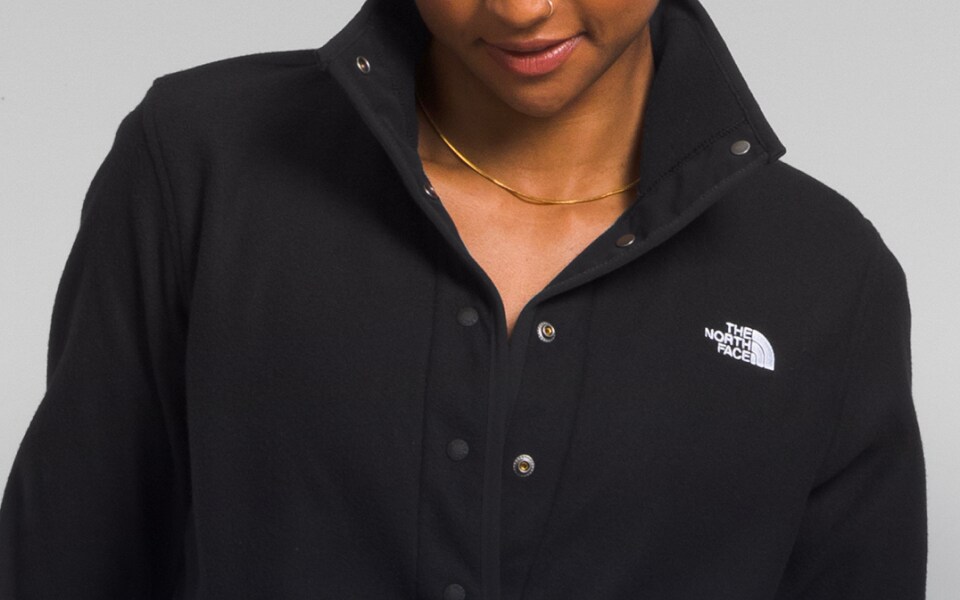 Studio shot of a woman in a black fleece from The North Face.