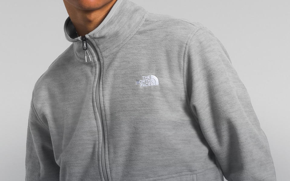 Studio shot of a man in a gray fleece from The North Face. 