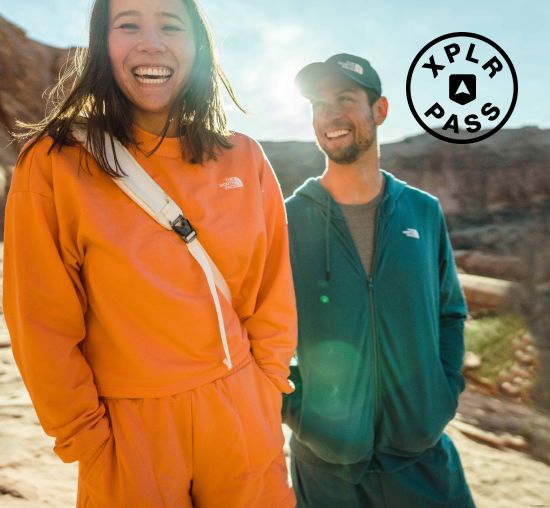 Three friends laughing outside, wearing gear from The North Face.