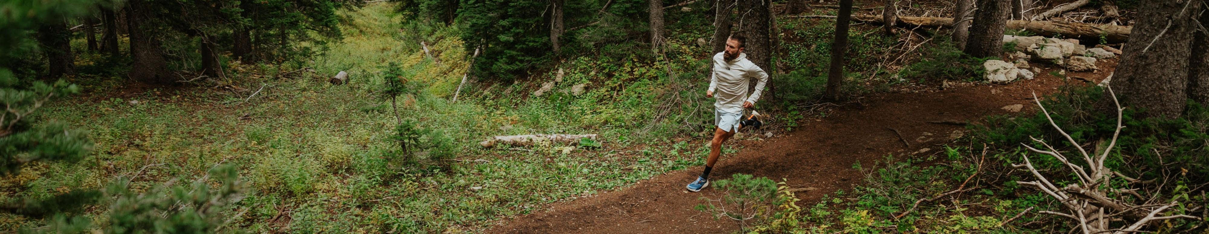 A man is trail running in the woods wearing gear from The North Face. Text reads: “Highly motivated. Ultra-prepared.” 