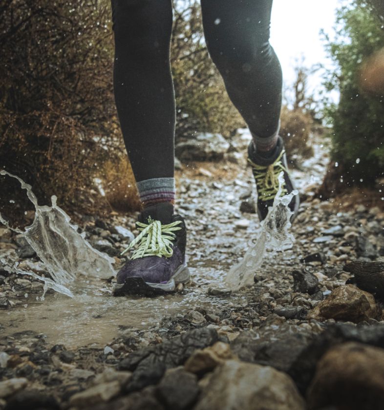  A person is trail running and making a big splash wearing trail shoes from The North Face. Text reads: “Tread boldly. No need to be too cautious when you’ve got a high-rebound midsole.” 