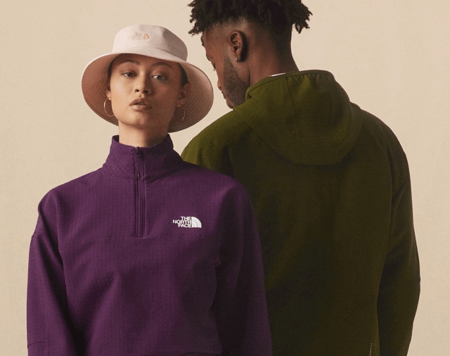 Studio shot of a man and a woman wearing fleece Tekware Jackets from The North Face in green and purple.  