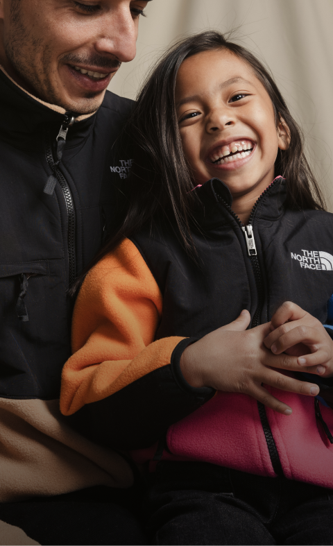 Studio shot of a man and child wearing Denali Fleece from The North Face.