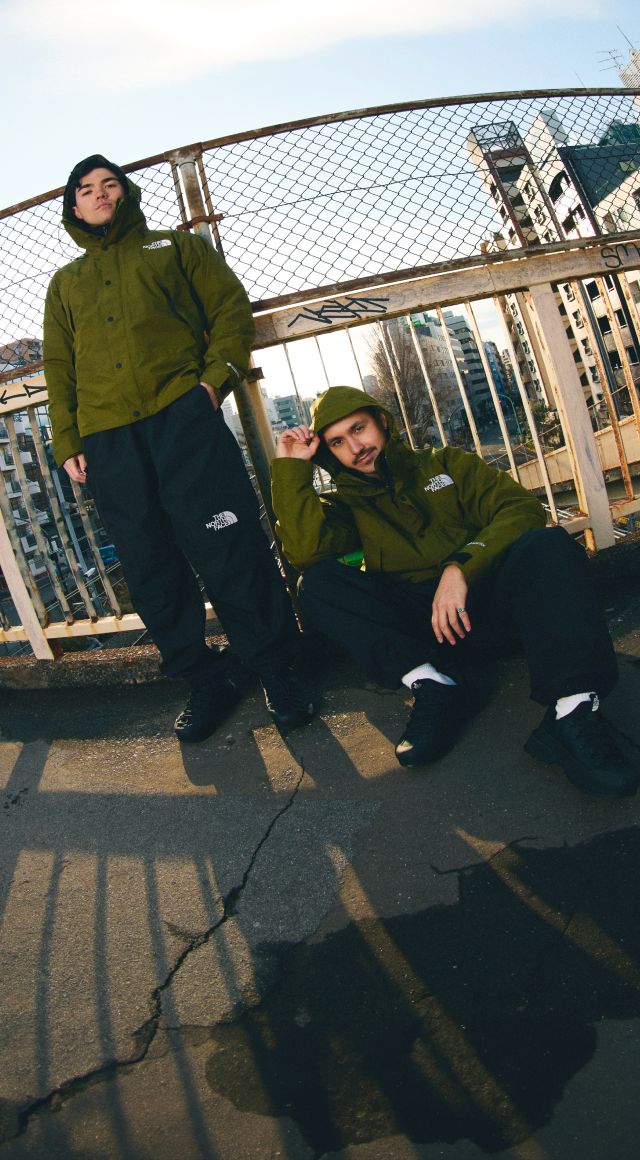 À gauche, deux personnes portant la veste de montagne GORE-TEX en milieu urbain. À droite, un gros-plan du logo The North Face Logo sur le manteau de montagne GORE-TEX, des gouttes d’eau perlant sur le tissu.