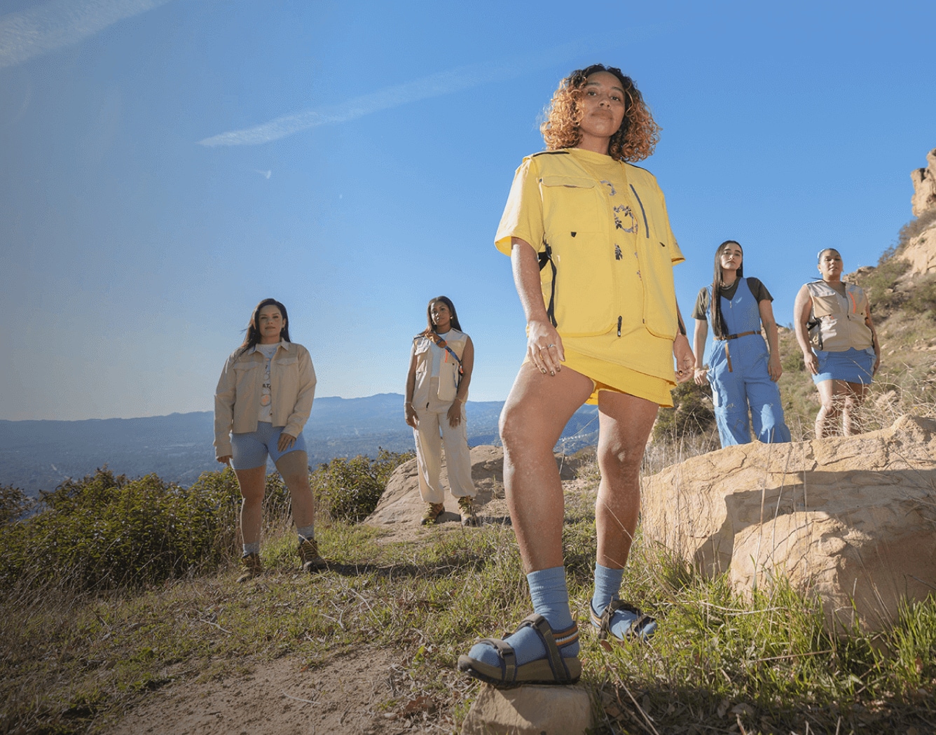 Explore Fund council member Evelynn Escobar and four women pose under blue skies wearing gear from The North Face Hike Clerb Capsule Collection.