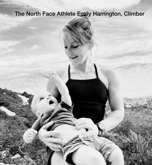 Black and white image of The North Face Athlete Emily Harrington holding her toddler while sitting in an alpine landscape.