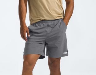 Studio shot of a man in gray shorts from The North Face.